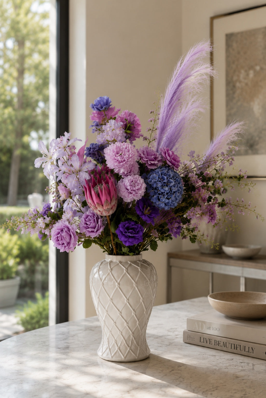 Monet-inspired Water Lily Collection artificial flower arrangement featuring pastel lavender, lilac, blush pink and soft blue blooms in a white ceramic vase, styled as elegant home décor in a bright sunlit interior.