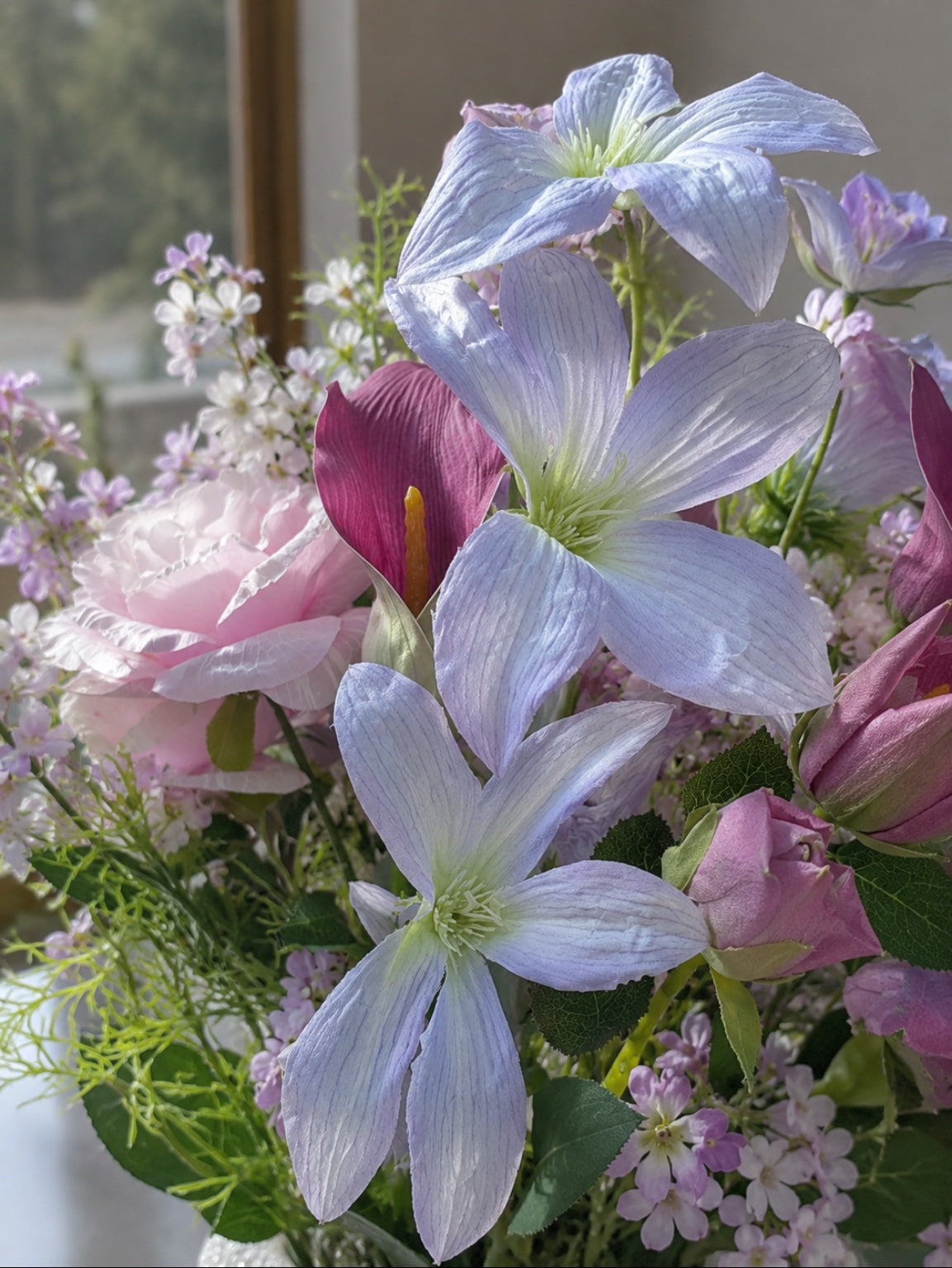 Close-up of the Water Lily Collection artificial floral arrangement showcasing pastel lavender blooms, blush pink roses and soft botanical accents in natural light.